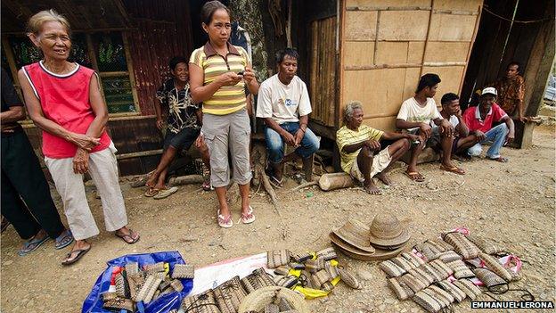 Local women selling woven bags, purses, and hats at the community center in Sitio Nagpana. The village has received little relief therefore the community tries to recover on its own.