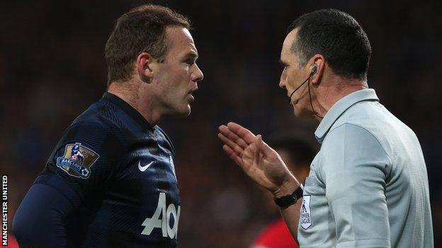 Manchester United striker Wayne Rooney makes a point to referee Neil Swarbrick after being booked against Cardiff