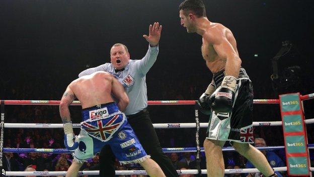 George Groves is held by referee Howard Foster as Carl Froch looks on