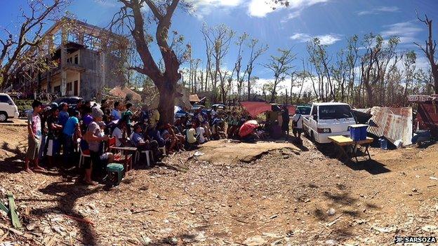 Residents of Estancia town on Panay Island, central Philippines gather around a TV set powered by a battery from a vehicle to watch the Pacquiao-Rios fight last Sunday. Beside them is their roofless Northern Iloilo Polytechnic State College. Photo: JP Sarsoza