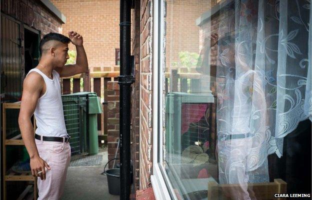 Jiri, 19, talks to his mother through the kitchen door