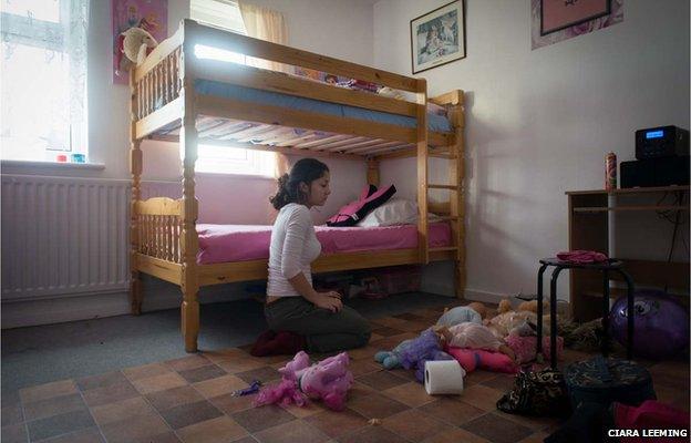 Fifteen-year-old Katerina tidies the room she shares with her nine-year-old sister Andrea