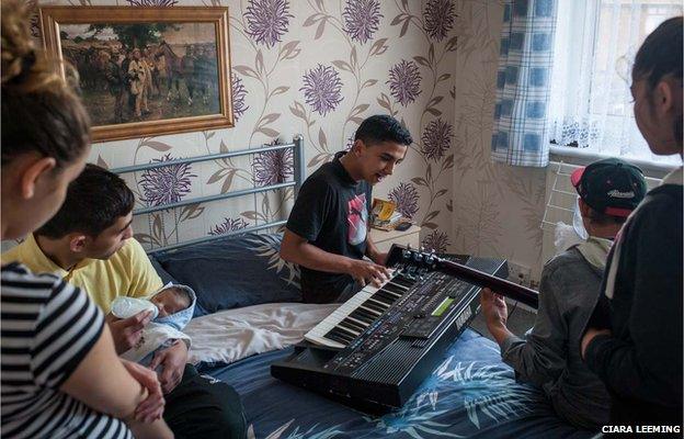 Family members gather to hear Jiri, 19, (centre) play music with a friend