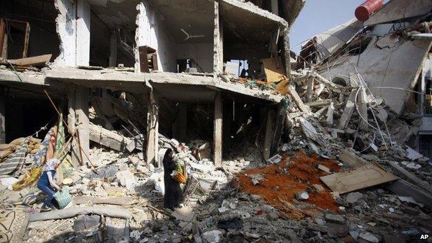 Syrian civilians look for undamaged furniture, clothes and food in their homes