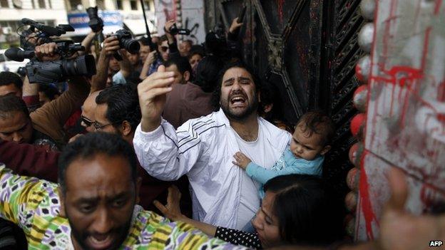 Egyptian pro-democracy activist and opponent of Egypt's ruling Muslim Brotherhood, Alaa Abd Fattah, arrives at the general prosecutor office in Cairo holding his son on March 26, 2013, to turn himself in for questioning, a day after an order for his arrest