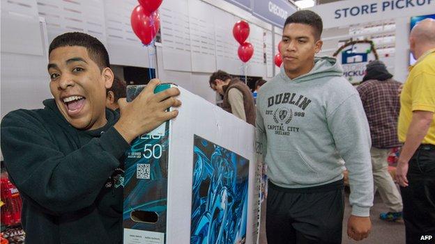 Black Friday shoppers carry out a purchased flat screen tv, seen here on Thursday November 28, 2013, at the Best Buy store in Fairfax, Virginia.