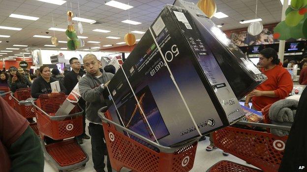 A man pushes two televisions in a shopping cart at a Target store in Colma, Calif., on Thanksgiving Day, Thursday, Nov. 28, 2013.