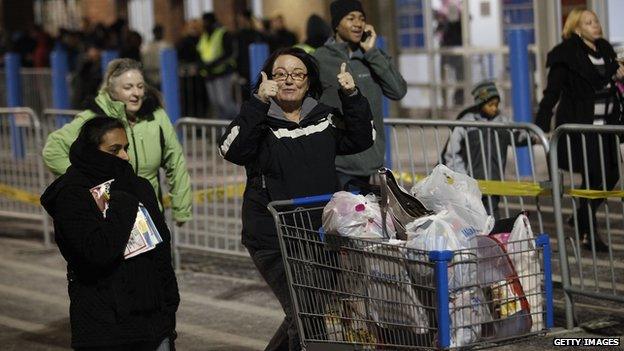 A customer gives the thumbs-up as she leaves with her purchased items outside Wal-Mart Thanksgiving day on November 28, 2013 in Troy, Michigan