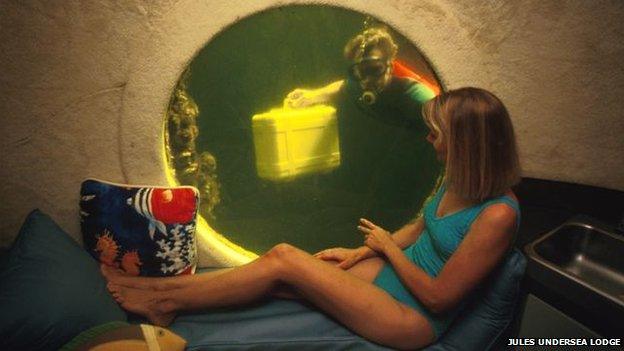 A woman looks out of the window of the Jules Undersea Lodge