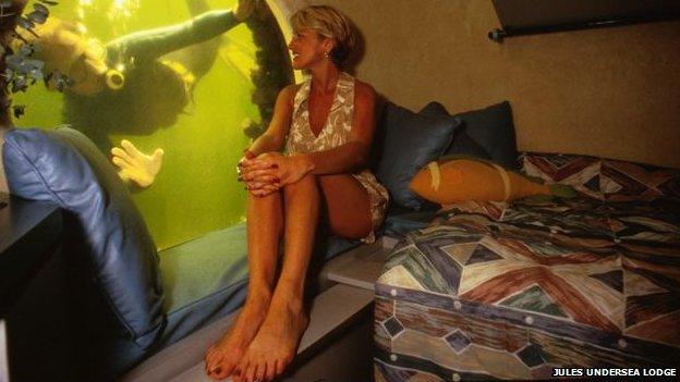 A woman looks out of the window of the Jules Undersea Lodge