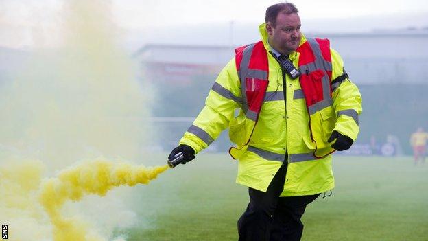 A steward gathers a flare from New Douglas Park on Saturday