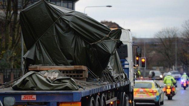 Helicopter wreckage being driven away