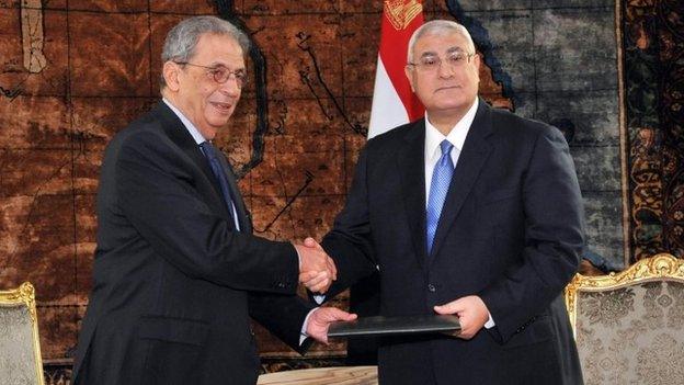 Amr Moussa (left), chairman of the constituent assembly, presents a copy of the draft constitution to interim President Adly Mansour (3 December 2013)