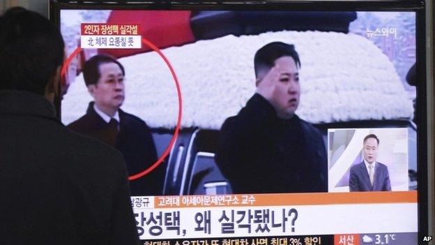 A man watches a TV news programme showing North Korean leader Kim Jong-un (R) and Chang Song-taek at Seoul Railway Station in Seoul, South Korea, on 3 December 2013