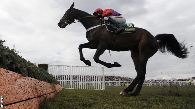 Barry Geraghty riding Sprinter Sacre jumps the last fence on his way to winning the third race of the day of The Melling Steeple Chase at Aintree in April 2013