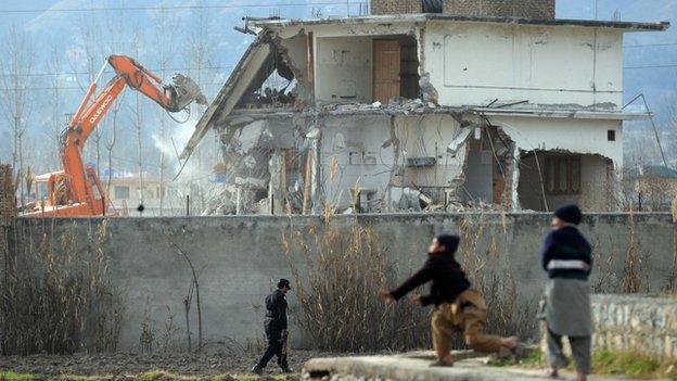 In this photograph taken on February 26, 2012, young Pakistani children play near demolition works on the compound where Al-Qaeda chief Osama bin Laden was slain in the northwestern town of Abbottabad