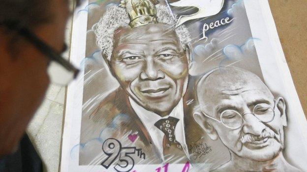 Indian artist Aejaz Saiyed works on a poster featuring the portraits of Nelson Mandela (L) and Mahatma Gandhi on Mandela's 95th birthday in the western Indian city of Ahmedabad July 18, 2013.