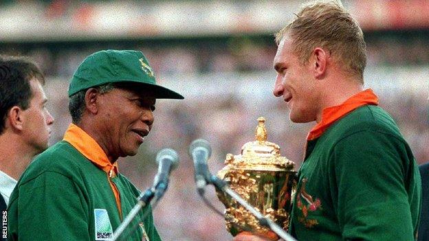 South African President Nelson Mandela (L) presents the William Webb Ellis Cup to Springbok captain Francois Pienaar