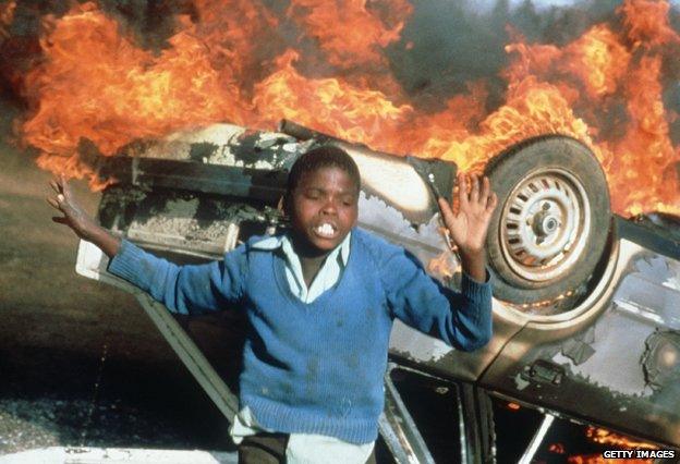 Boy in front of burning car, Duduza township 1985