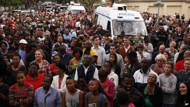 A group of people gather for a prayer service outside the home of former president Nelson Mandela