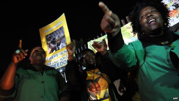 People sing to pay a tribute to late former South African president Nelson Mandela outside his former house in Soweto on 6 December, 2013