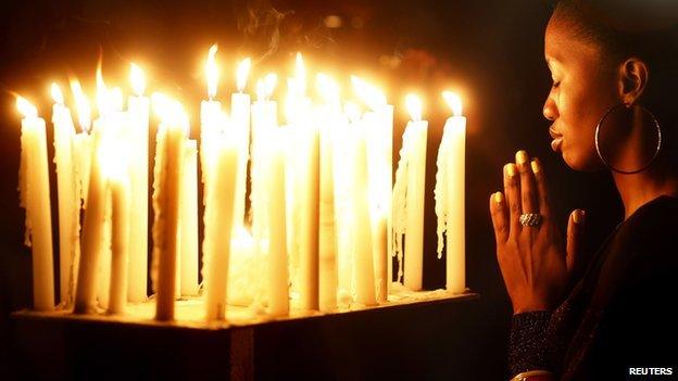 Woman prays for Nelson Mandela in Johannesburg, South Africa