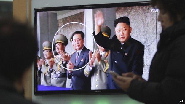 People watch a TV news programme showing an image of North Korean leader Kim Jong-un, right, and his uncle, Chang Song-thaek, third from left, at the Seoul Railway Station in Seoul, South Korea, 9 December 2013