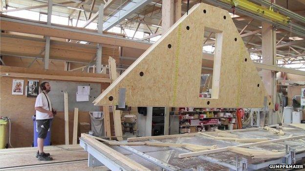 Wood panel being crane-lifted in factory