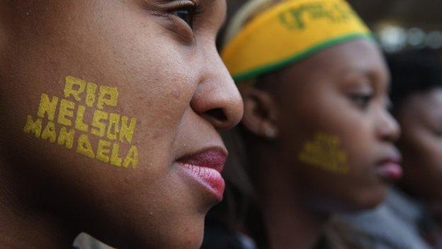 Two young women attend the official memorial service for former South African President Nelson Mandela in Johannesburg (10 December 2013)