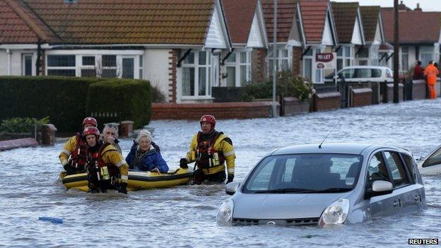 Rescuers take people to safety on a lifeboat