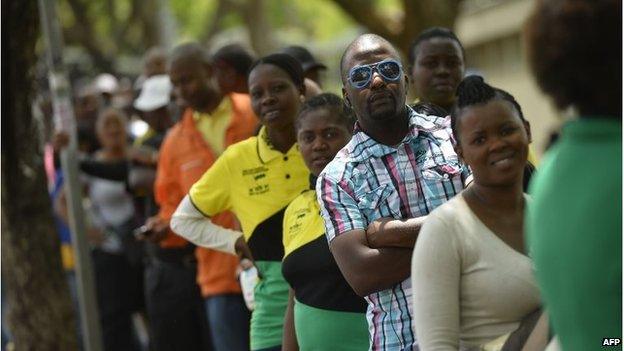 People queue to watch former South African President Nelson Mandela's coffin at the Union Buildings on December 11