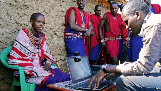 A woman registers to vote with an official with a laptop in a village in Kaijado County, December 2012