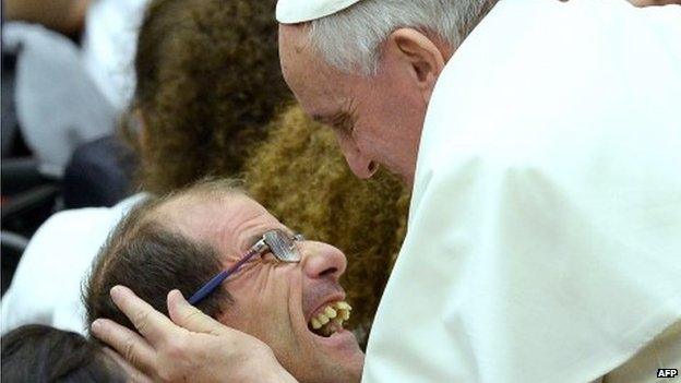 Pope Francis embraces a disabled man at the Vatican on 9 November