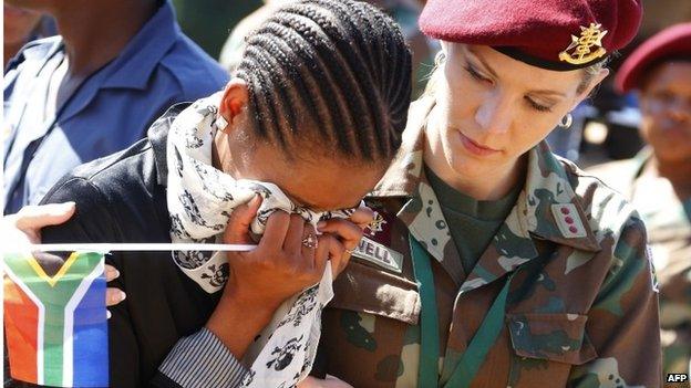 A woman cries after paying her respects to South African former President Nelson Mandela, 12th December