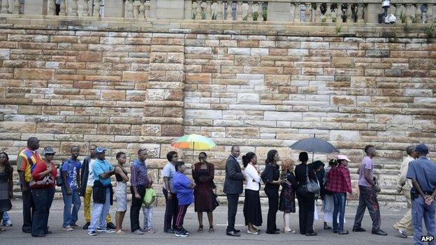 South Africans stand in line to pay their respect to South African former president Nelson Mandela