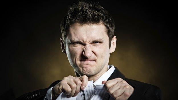 man looking unhappy and ripping up paper