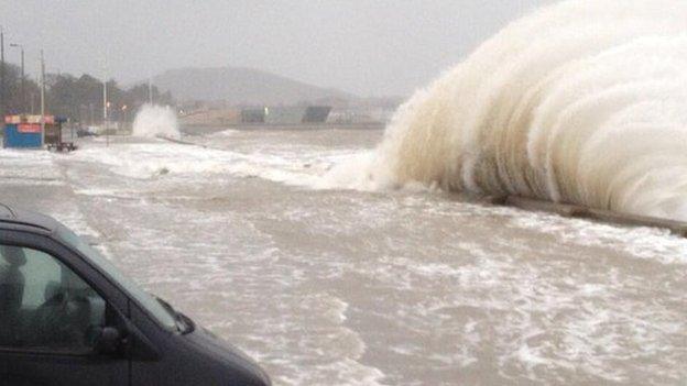 Waves crash over the sea wall at Porth Eirias, Colwyn Bay