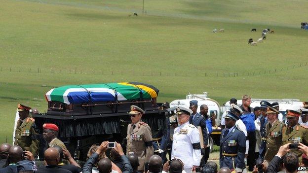 Nelson Mandela's coffin is taken to his final resting place in Qunu by a military guard of honour