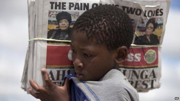 A boy carries newspapers in Nelson Mandela's home village of Qunu