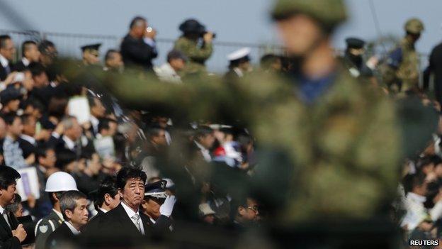 Japanese Prime Minister Shinzo Abe (bottom 3rd L) reviews Japan Self-Defence Forces troops during the annual SDF ceremony at Asaka Base near Tokyo on October 27, 2013