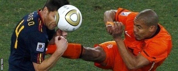 Nigel de Jong tackles Xabi Alonso