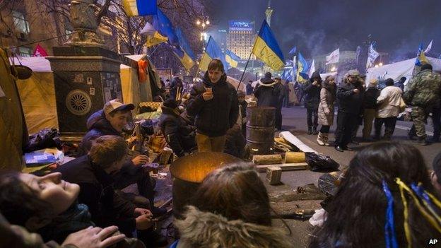 Pro-European Union activists warm themselves by a fire in Kiev