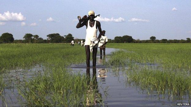 People from the Luo Nuer ethnic who recently came back from fighting walk in the river in Yuai, Uror county South Sudan, 24 July 2013