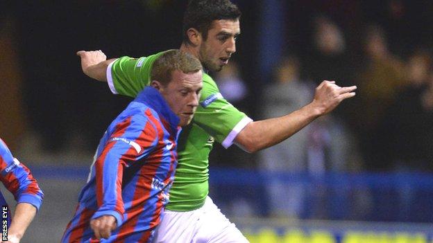 An Ards player challenges Cliftonville striker Joe Gormley