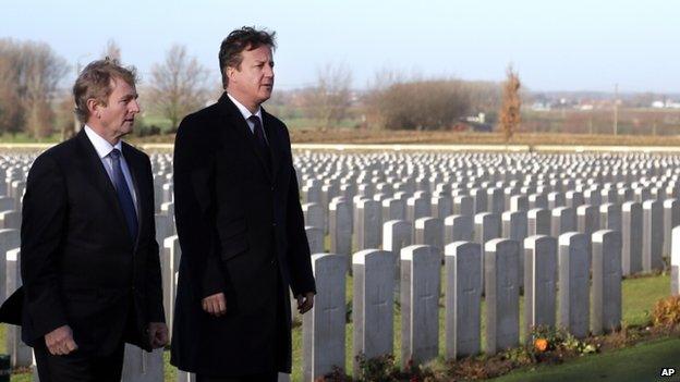 British Prime Minister David Cameron, right, and Irish Prime Minister Enda Kenny walk through rows of World War One graves as they visit Tyne Cot Cemetery in Zonnebeke, Belgium on Thursday, Dec. 19, 2013.