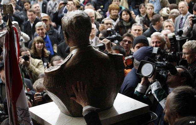 Photographers, cameramen and visitors crowd around a statue-bust of Hungary's wartime leader Miklos Horthy after it was unveiled in Budapest on November 3, 2013. The unveiling provoked protests of antifascist demonstrators.