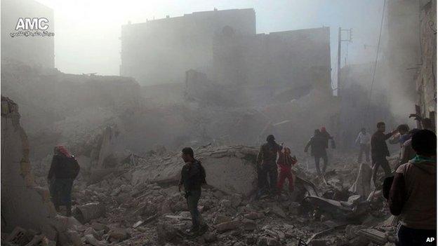 Syrians inspect the rubble of damaged buildings following a Syrian government airstrike in Aleppo on 17 December.