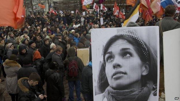 Demonstrators hold flags and a portrait, front, of jailed punk band Pussy Riot member Nadezhda Tolokonnikova, during an opposition rally in Moscow, Saturday, April 6, 2013