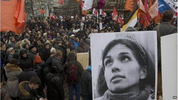 Demonstrators hold flags and a portrait, front, of jailed punk band Pussy Riot member Nadezhda Tolokonnikova, during an opposition rally in Moscow, April 6