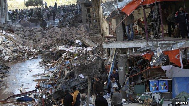 People look at the damage after an explosion near a security building in Mansoura